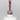 Nahaufnahme einer offenen Longlife UV-Lack Glam Glitter Lillet Berry Flasche. Die Farbe ist ein dunkles Rosa mit sehr viel Glitzer. Der UV-Nagellack tropft am Pinsel herunter.