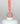 Nahaufnahme einer offenen Longlife UV-Lack Living Coral Flasche. Die Farbe ist ein helles Orange mit hoher Sättigung. Der UV-Nagellack tropft am Pinsel herunter.