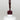 Nahaufnahme einer offenen Longlife UV-Lack Rouge Noir Flasche. Die Farbe ist ein dunkles Rot mit leichtem Braunstich. Der UV-Lack tropft am Pinsel herunter.
