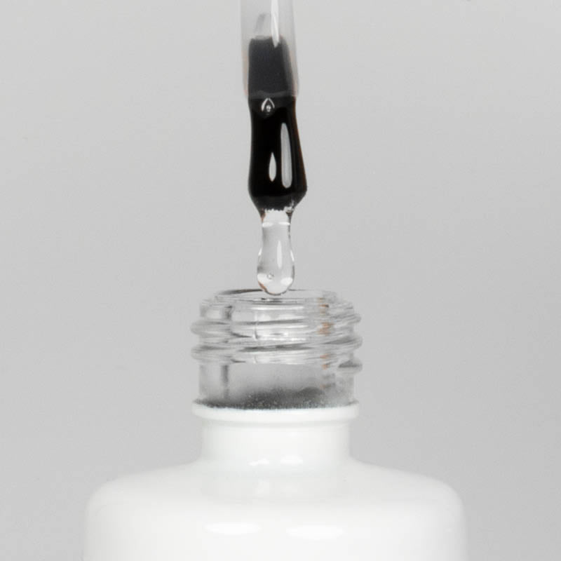 Nahaufnahme einer offenen Longlife UV-Lack Base/Top Flasche. Die Farbe ist transparent. Der UV-Nagellack tropft am Pinsel herunter.