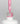Nahaufnahme einer offenen Longlife UV-Lack Bella Alexa Flasche. Die Farbe ist ein Pink mit Glitzer Effekt. Der UV-Nagellack tropft am Pinsel herunter.