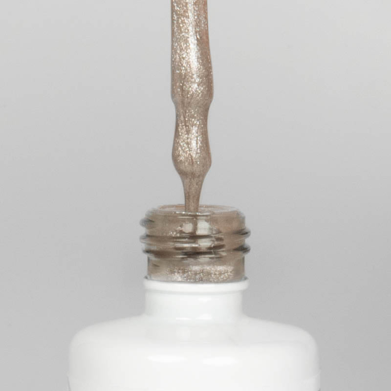 Nahaufnahme einer offenen Longlife UV-Lack Bella Bianca Flasche. Die Farbe ist ein Nude mit Metallic Effekt. Der UV-Nagellack tropft am Pinsel herunter.