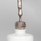 Nahaufnahme einer offenen Longlife UV-Lack Bella Jana Flasche. Die Farbe ist ein dunkles silber-Nude mit Metallic-Effekt. Der UV-Nagellack tropft am Pinsel herunter.