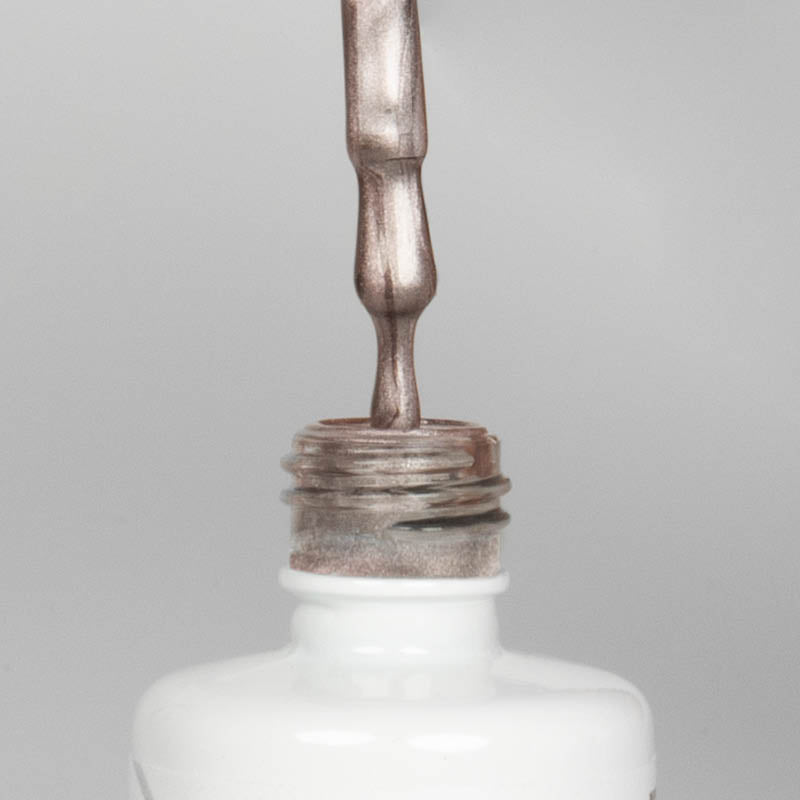 Nahaufnahme einer offenen Longlife UV-Lack Bella Jana Flasche. Die Farbe ist ein dunkles silber-Nude mit Metallic-Effekt. Der UV-Nagellack tropft am Pinsel herunter.