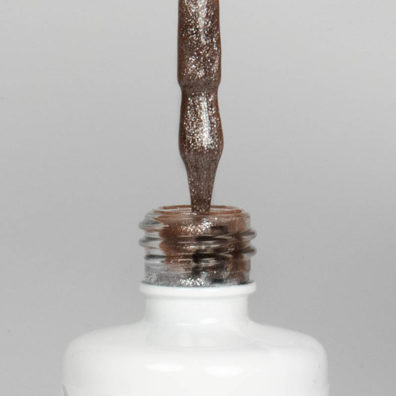 Nahaufnahme einer offenen Longlife UV-Lack Bella Katja Flasche. Die Farbe ist ein dunkles Braun mit Glitzer-Effekt. Der UV-Nagellack tropft am Pinsel herunter.