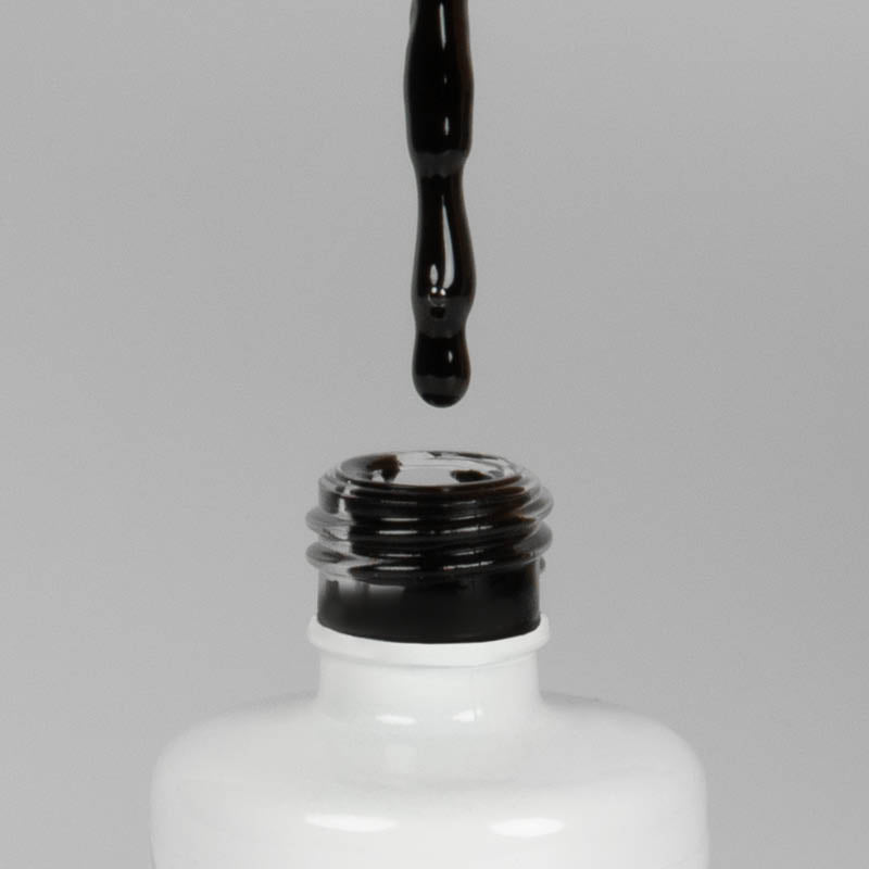 Nahaufnahme einer offenen Longlife UV-Lack Black Flasche. Die Farbe ist schwarz. Der UV-Nagellack tropft am Pinsel herunter.