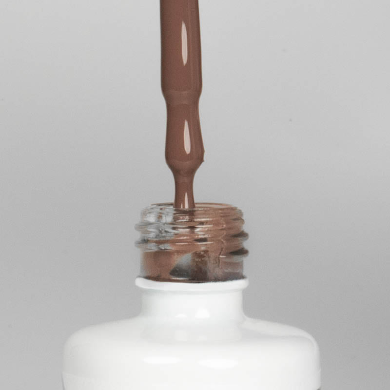 Nahaufnahme einer offenen Longlife UV-Lack Brownie Flasche. Die Farbe ist ein dunkles Nude. Der UV-Nagellack tropft am Pinsel herunter.