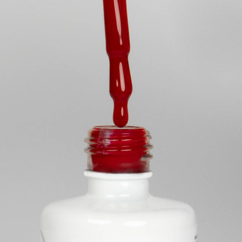 Nahaufnahme einer offenen Longlife UV-Lack Chianti Flasche. Die Farbe ist ein dunkles Rot. Der UV-Nagellack tropft am Pinsel herunter.