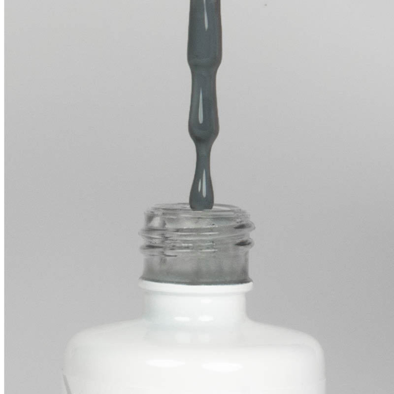 Nahaufnahme einer offenen Longlife UV-Lack Dark Grey Flasche. Die Farbe ist ein dunkles Grau. Der UV-Nagellack tropft am Pinsel herunter.