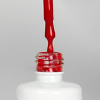 Nahaufnahme einer offenen Longlife UV-Lack Deluxe Red Flasche. Die Farbe ist ein knalliges Rot. Der UV-Nagellack tropft am Pinsel herunter.