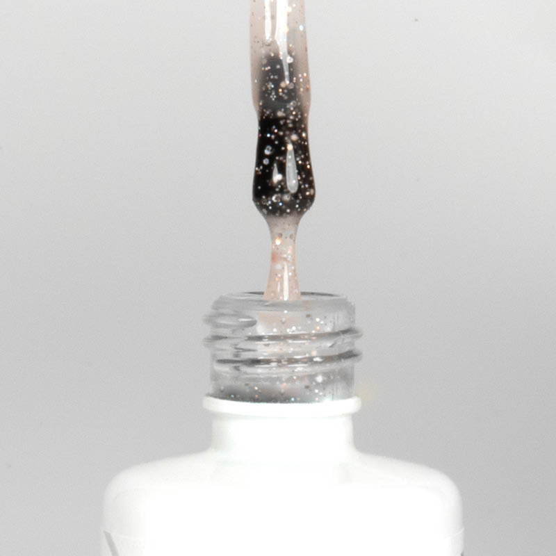 Nahaufnahme einer offenen Longlife UV-Lack Egg Shell Matt Rose Flasche. Die Farbe ist transparent mit rosé-goldenen Partikeln. Der UV-Nagellack tropft am Pinsel herunter.