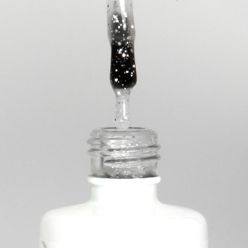Nahaufnahme einer offenen Longlife UV-Lack Egg Shell Matt Silver Flasche. Die Farbe ist transparent mit silbernen Partikeln. Der UV-Nagellack tropft am Pinsel herunter.