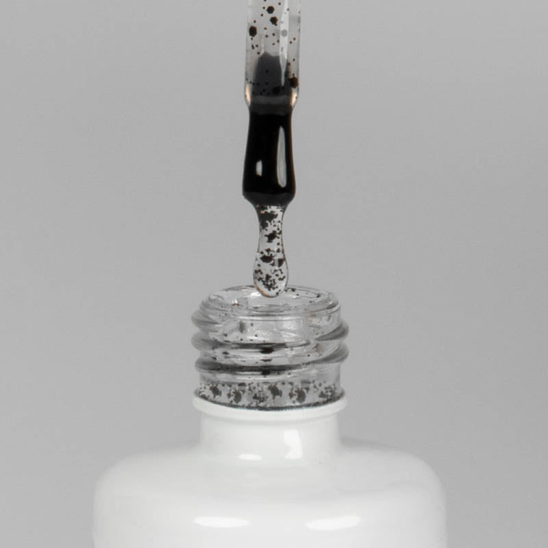 Nahaufnahme einer offenen Longlife UV-Lack Egg Shell Shiny Black Flasche. Die Farbe ist transparent mit schwarzen Partikeln. Der UV-Nagellack tropft am Pinsel herunter.