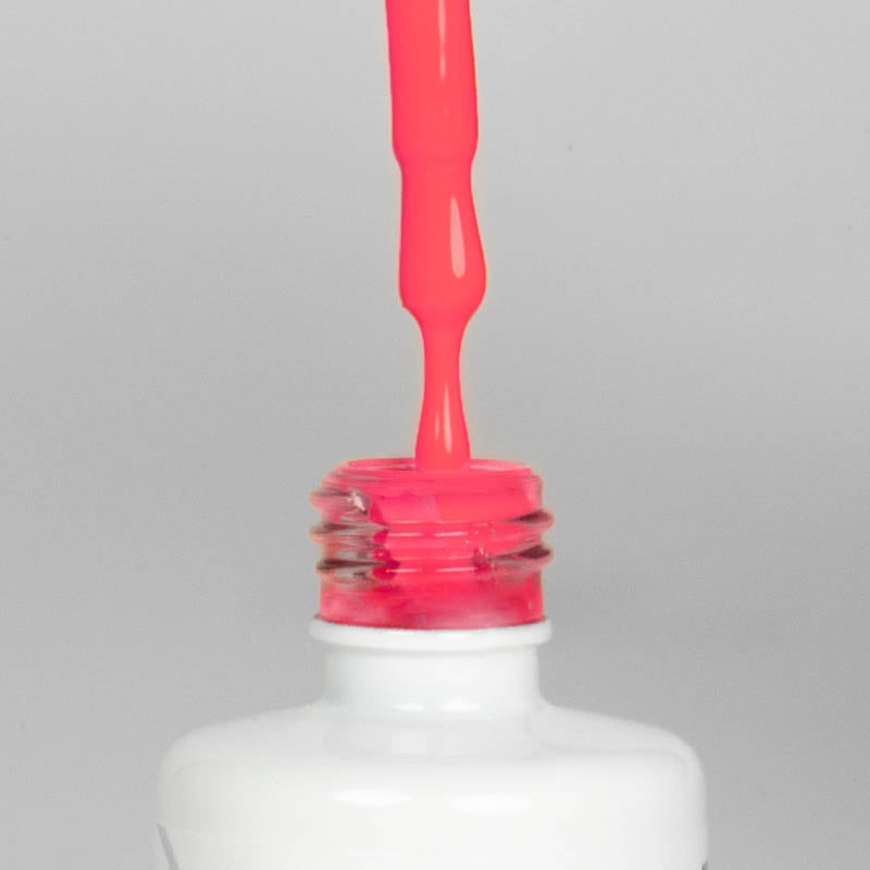 Nahaufnahme einer offenen Longlife UV-Lack Feminista Flasche. Die Farbe ist ein knalliges Pink mit hoher Sättigung. Der UV-Nagellack tropft am Pinsel herunter.