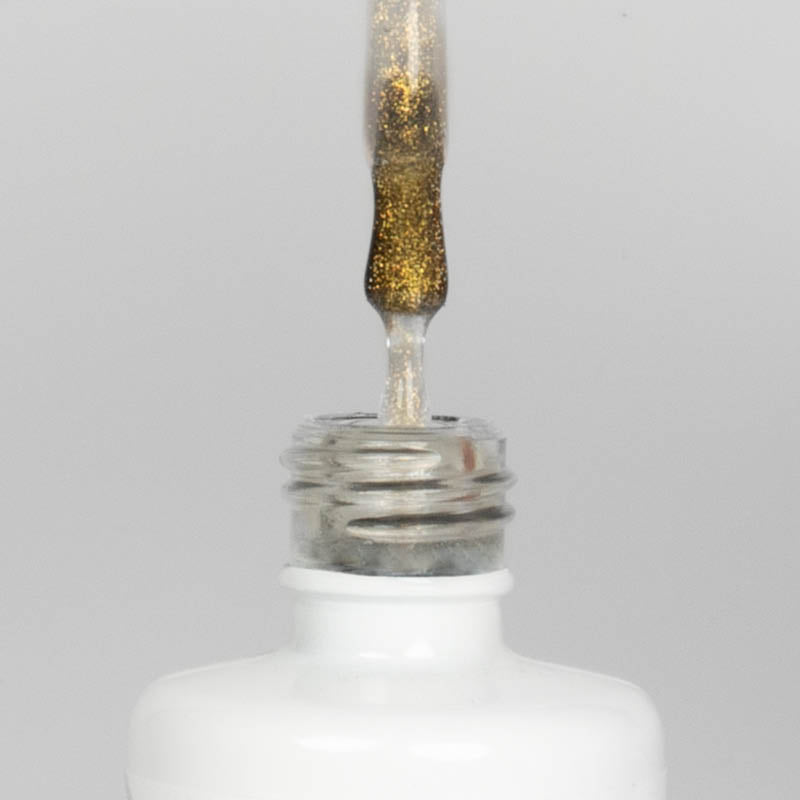 Nahaufnahme einer offenen Longlife UV-Lack Gold Gloss Flasche. Die Farbe ist transparent mit goldenem Glitzer. Der UV-Nagellack tropft am Pinsel herunter.