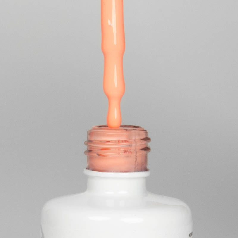 Nahaufnahme einer offenen Longlife UV-Lack Happy Day Flasche. Die Farbe ist ein helles, knalliges Orange. Der UV-Nagellack tropft am Pinsel herunter.