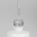 Nahaufnahme einer offenen Longlife UV-Lack Light Grey Flasche. Die Farbe ist ein helles Grau. Der UV-Nagellack tropft am Pinsel herunter.