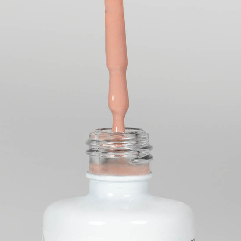 Nahaufnahme einer offenen Longlife UV-Lack Light Nude Flasche. Die Farbe ist ein helles Nude. Der UV-Nagellack tropft am Pinsel herunter.