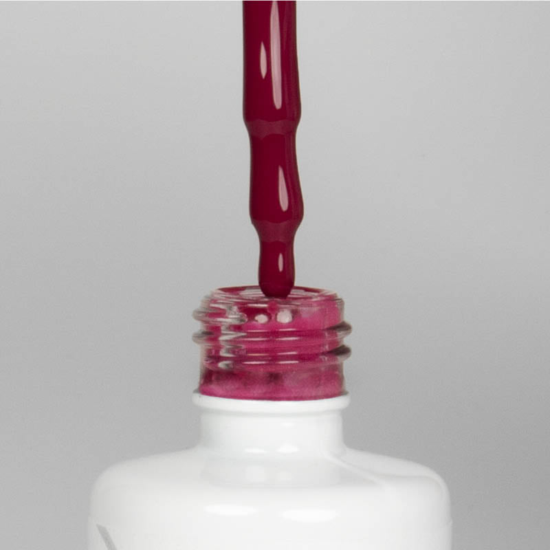 Nahaufnahme einer offenen Longlife UV-Lack Lolli Pink Flasche. Die Farbe ist ein dunkles Rosa. Der UV-Nagellack tropft am Pinsel herunter.