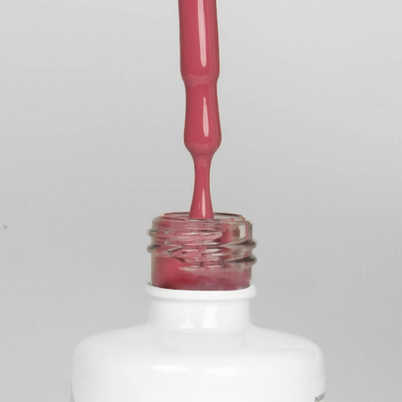 Nahaufnahme einer offenen Longlife UV-Lack Malta Rose Flasche. Die Farbe ist ein dunkles Rosa. Der UV-Nagellack tropft am Pinsel herunter.