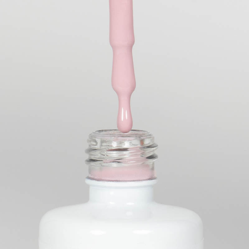 Nahaufnahme einer offenen Longlife UV-Lack Mellow Rose Flasche. Die Farbe ist ein helles Rosa mit niedriger Sättigung. Der UV-Nagellack tropft am Pinsel herunter.