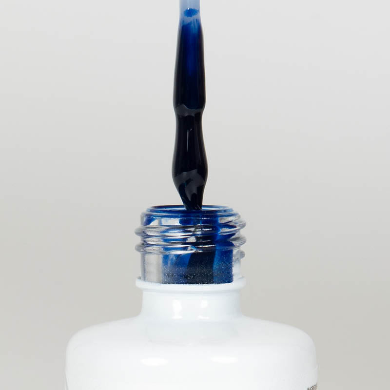 Nahaufnahme einer offenen Longlife UV-Lack Midnight Blue Flasche. Die Farbe ist ein sehr dunkles Blau mit hoher Sättigung. Der UV-Lack tropft am Pinsel herunter.