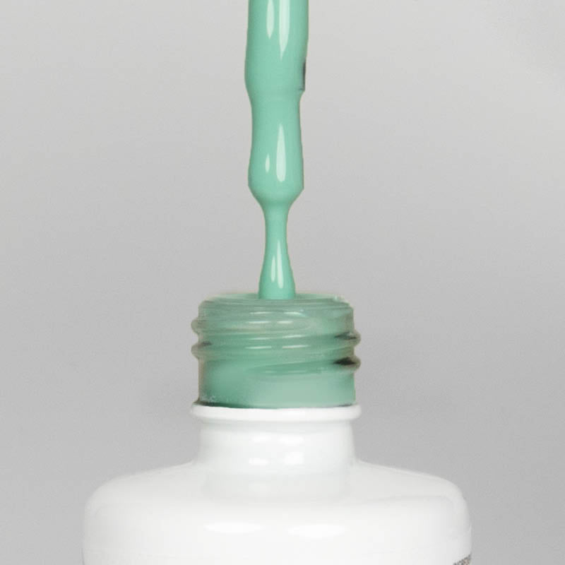 Nahaufnahme einer offenen Longlife UV-Lack Mint Flasche. Die Farbe ist ein helles Grün mit hoher Sättigung. Der UV-Lack tropft am Pinsel herunter.