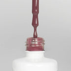 Nahaufnahme einer offenen Longlife UV-Lack Mulberry Flasche. Die Farbe ist ein Rosa mit niedriger Sättigung. Der UV-Lack tropft am Pinsel herunter.