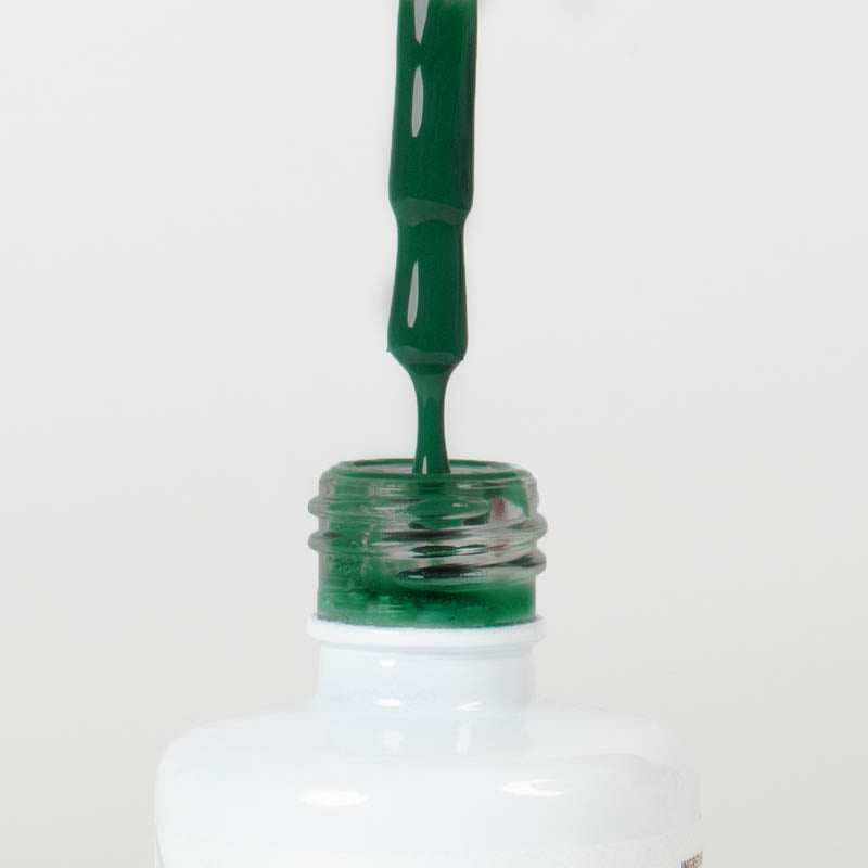 Nahaufnahme einer Longlife UV-Lack Flasche der Farbe Ultramarine Green. Die Farbe ist ein dunkles Grün mit hoher Sättigung. Der UV-Lack tropft am Pinsel herunter.