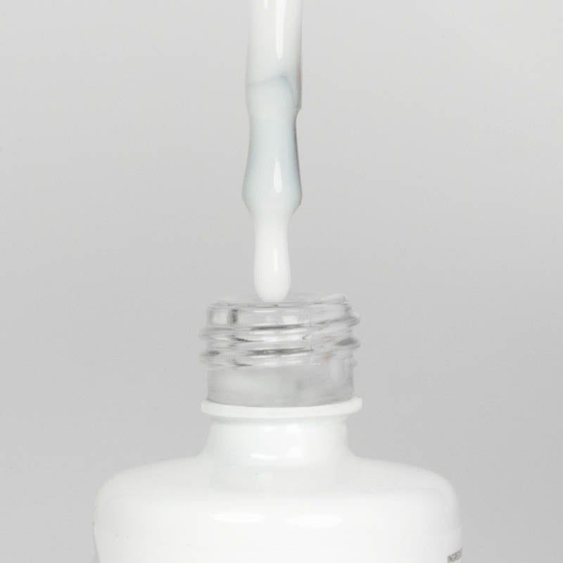 Nahaufnahme einer offenen Longlife UV-Lack Natural White Flasche. Die Farbe ist ein Off_White. Der UV-Nagellack tropft am Pinsel herunter.