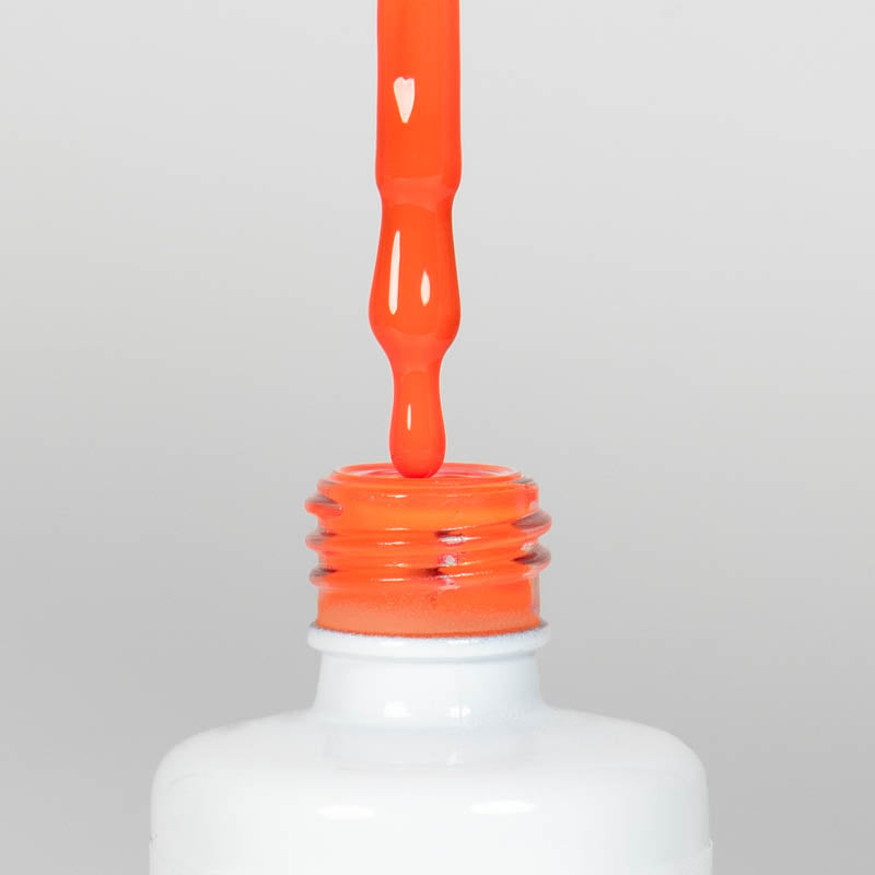 Nahaufnahme einer offenen Longlife UV-Lack Neon Coral Flasche. Die Farbe ist ein knalliges Orange mit Rot-Stich mit hoher Sättigung. Der UV-Lack tropft am Pinsel herunter.