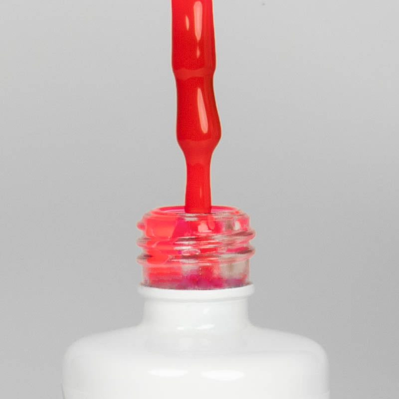 Nahaufnahme einer offenen Longlife UV-Lack Neon Cyclam Flasche. Die Farbe ist ein knalliges Pink mit Rot-Stich mit hoher Sättigung. Der UV-Lack tropft am Pinsel herunter.