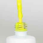 Nahaufnahme einer offenen Longlife UV-Lack Neon Lemon Flasche. Die Farbe ist ein knalliges Gelb mit hoher Sättigung. Der UV-Lack tropft am Pinsel herunter.