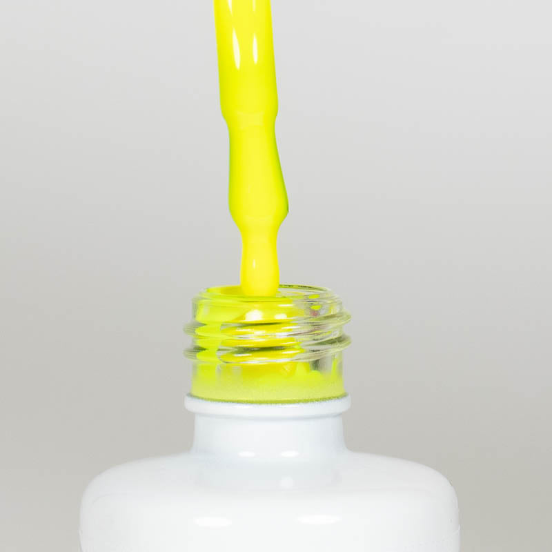 Nahaufnahme einer offenen Longlife UV-Lack Neon Lemon Flasche. Die Farbe ist ein knalliges Gelb mit hoher Sättigung. Der UV-Lack tropft am Pinsel herunter.
