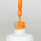 Nahaufnahme einer offenen Longlife UV-Lack Neon Mandarine Flasche. Die Farbe ist ein knalliges Orange mit hoher Sättigung. Der UV-Lack tropft am Pinsel herunter.