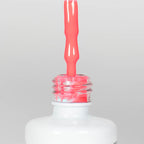 Nahaufnahme einer offenen Longlife UV-Lack Neon Pink Flasche. Die Farbe ist ein knalliges Pink mit hoher Sättigung. Der UV-Lack tropft am Pinsel herunter.