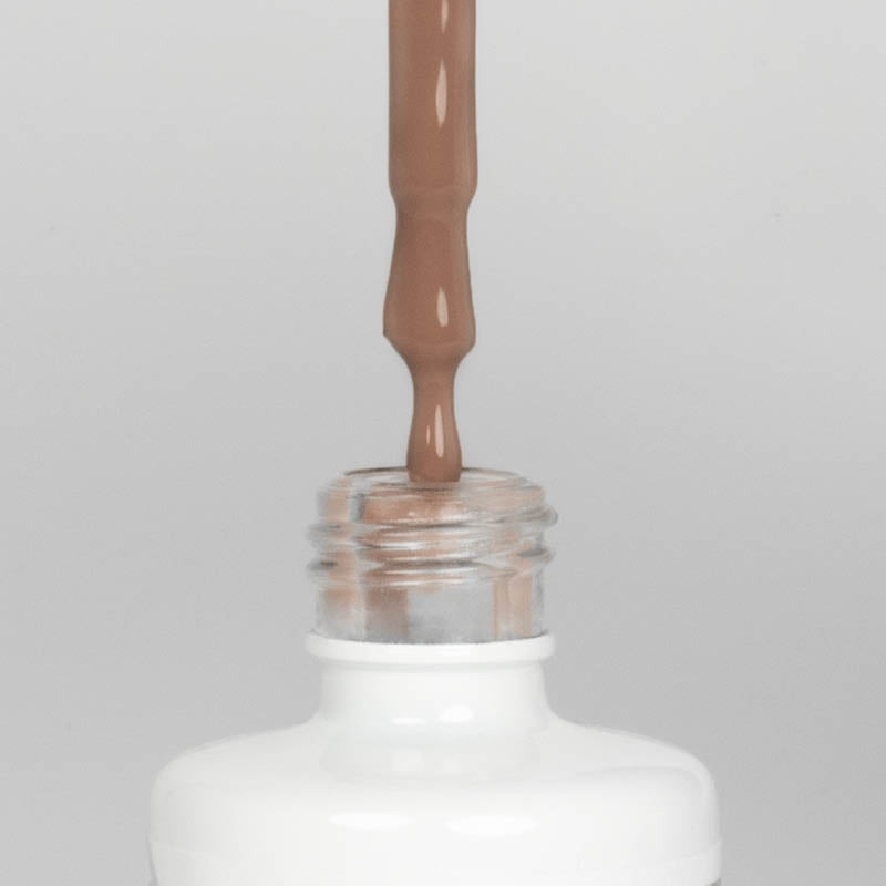 Nahaufnahme einer offenen Longlife UV-Lack Nude Flasche. Die Farbe ist ein warmer Nude-Ton mit hoher Sättigung. Der UV-Lack tropft am Pinsel herunter.