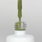 Nahaufnahme einer offenen Longlife UV-Lack Olive Flasche. Die Farbe ist ein Grün mit niedriger Sättigung. Der UV-Lack tropft am Pinsel herunter.