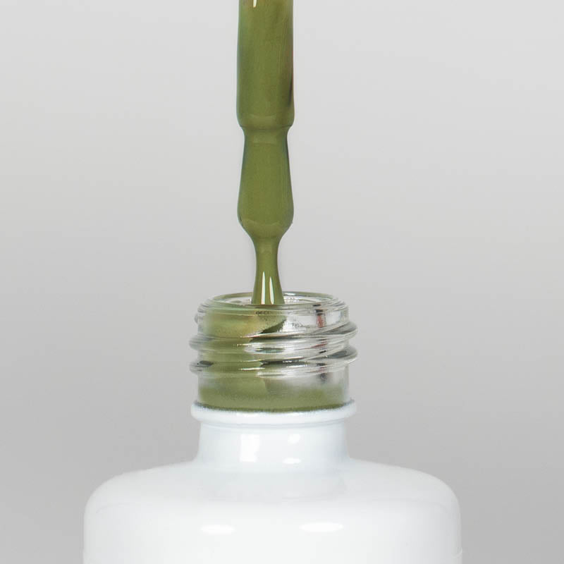 Nahaufnahme einer offenen Longlife UV-Lack Olive Flasche. Die Farbe ist ein Grün mit niedriger Sättigung. Der UV-Lack tropft am Pinsel herunter.