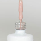 Nahaufnahme einer offenen Longlife UV-Lack Pale Dogwood Flasche. Die Farbe ist ein helles Nude mit hoher Sättigung. Der UV-Lack tropft am Pinsel herunter.