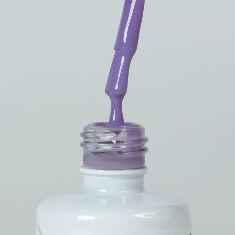 Nahaufnahme einer offenen Longlife UV-Lack Paradise Flasche. Die Farbe ist ein helles Violett mit niedriger Sättigung. Der UV-Lack tropft am Pinsel herunter.