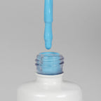 Nahaufnahme einer offenen Longlife UV-Lack Pastel Blue Flasche. Die Farbe ist ein knalliges helles Blau. Der UV-Lack tropft am Pinsel herunter.