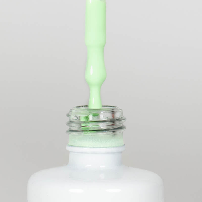 Nahaufnahme einer offenen Longlife UV-Lack Pistachio Flasche. Die Farbe ist ein sehr helles Grün. Der UV-Lack tropft am Pinsel herunter.