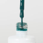 Nahaufnahme einer offenen Longlife UV-Lack Quetzal Green Flasche. Die Farbe ist ein Türkis. Der UV-Lack tropft am Pinsel herunter.