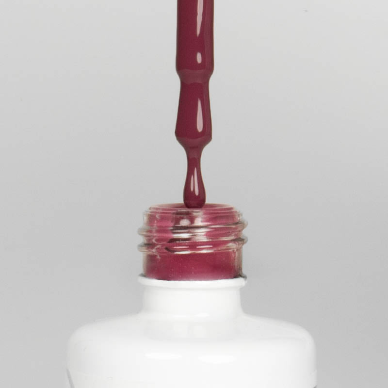 Nahaufnahme einer offenen Longlife UV-Lack Romantic Flasche. Die Farbe ist ein dunkles Rosa mit niedriger Sättigung. Der UV-Lack tropft am Pinsel herunter.