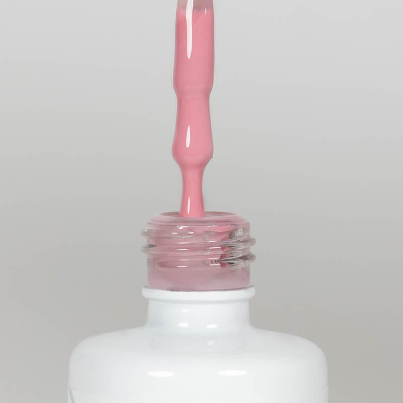 Nahaufnahme einer offenen Longlife UV-Lack Rosie Flasche. Die Farbe ist ein Rosa mit hoher Sättigung. Der UV-Lack tropft am Pinsel herunter.