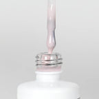 Nahaufnahme einer Longlife UV-Lack Rubber Base Cover One Flasche. Die Farbe ist durchscheinend Rosa. Der UV-Lack tropft am Pinsel herunter.