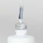 Nahaufnahme einer Longlife UV-Lack Rubber Base Cover Pearl White Flasche. Die Farbe ist durchscheinend Weiß mit Perl-Effekt. Der UV-Lack tropft am Pinsel herunter.