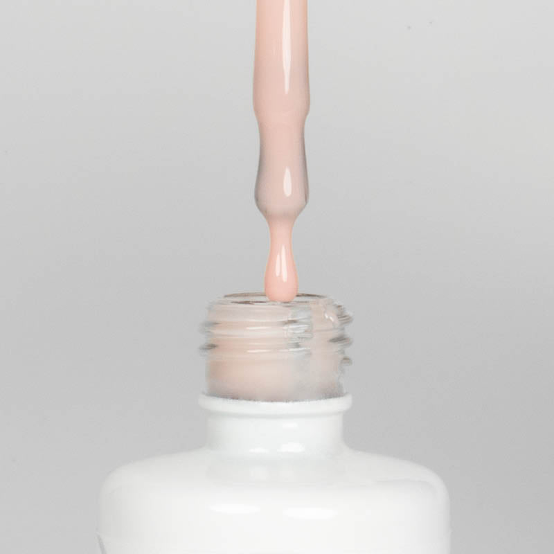 Nahaufnahme einer Longlife UV-Lack Rubber Base Cover Two Flasche. Die Farbe ist durchscheinend Nude mit Orange/Pink-Stich. Der UV-Lack tropft am Pinsel herunter.
