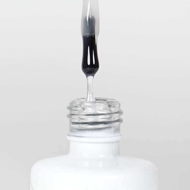 Nahaufnahme einer Longlife UV-Lack Rubber Base Flasche. Die Farbe ist transparent. Der UV-Lack tropft am Pinsel herunter.